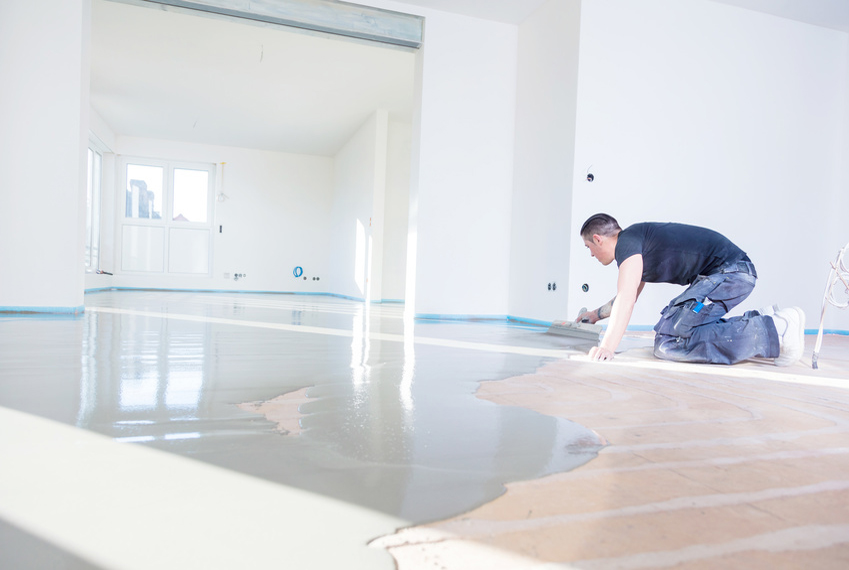 Handwerker beim Auslegen eines Fließestrichs